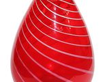 a red vase that is sitting on a white surface