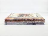 three books stacked on top of each other on a white surface