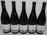 six bottles of wine are lined up in a row on a table