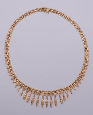 un collier en or orné de franges sur fond blanc