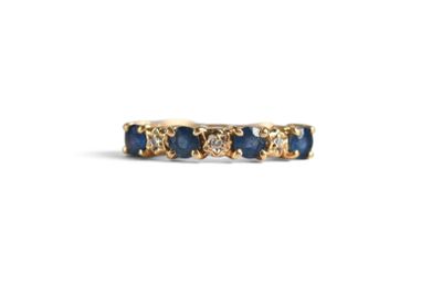 a close up of a gold ring with blue sapphires and diamonds