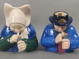 deux figurines représentant un homme et une femme portant des masques à gaz