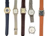 cinq modèles de montres différents sur fond blanc