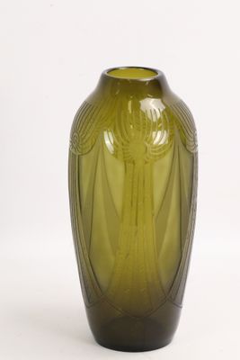 un vase vert posé sur une surface blanche