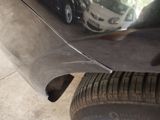 a close up of a car ' s bumper with a reflection of a car in the mirror