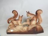 a figurine of a squirrel and a squirrel on a rock