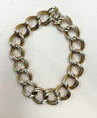 gros plan d'un bracelet en chaîne en argent sur une surface blanche