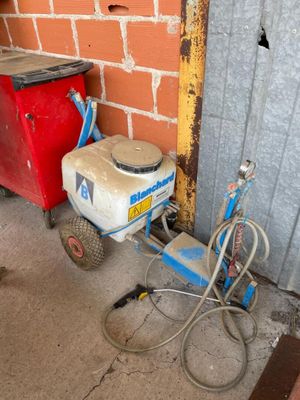 une petite machine posée à côté d'une poubelle