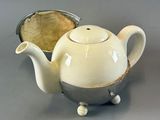 a white tea pot sitting on a table next to a pie