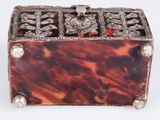 an antique tortoise shell box with silver and red beads