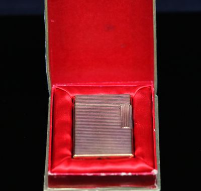 un petit étui à cigarettes en argent dans une boîte rouge