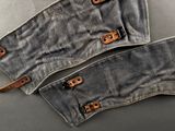 two pieces of denim with leather straps are laying on a table