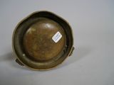 a small metal bowl with a tag on it