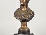 a bronze bust of a woman on a marble base