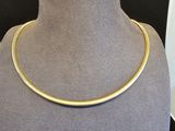 un gros plan d'un collier en or autour du cou d'un mannequin