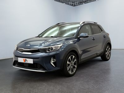 Une voiture grise est garée dans une pièce au sol noir.