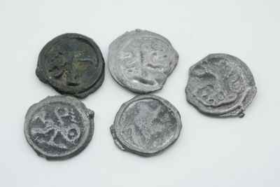 quatre pièces de monnaie anciennes sont disposées en rangée sur une surface blanche