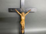 un crucifix en bois représentant Jésus sur la croix, sur fond gris
