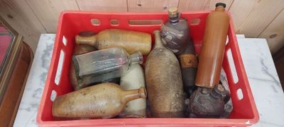 un panier rouge rempli de bouteilles, posées sur une table