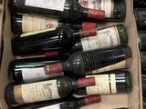 Les bouteilles de vin se trouvent dans un carton posé sur un sol carrelé.