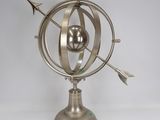 an image of a metal sculpture of a globe with arrows