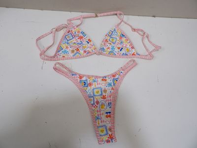 une photo représentant un haut de bikini et une culotte posés sur une surface blanche