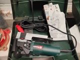 une boîte à outils verte posée par terre, contenant des outils