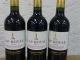trois bouteilles de vin posées sur une table en bois