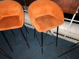 two orange chairs sitting next to each other in a room