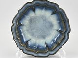a blue plate with a design on it on a stand