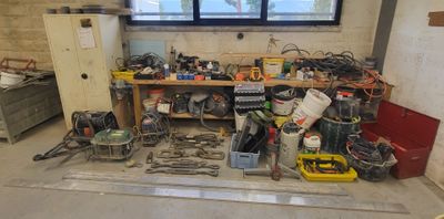 un établi sur lequel sont posés des outils, dans une pièce