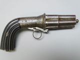 un gros plan d'un pistolet posé sur une table, sur lequel est posé un anneau