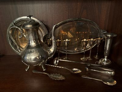 une théière en argent et des cuillères en argent posées sur une table