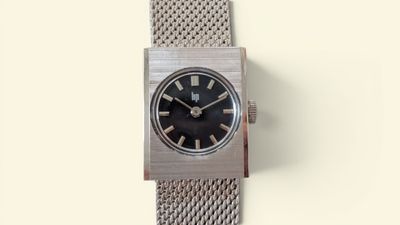a silver watch with a black face on a white background