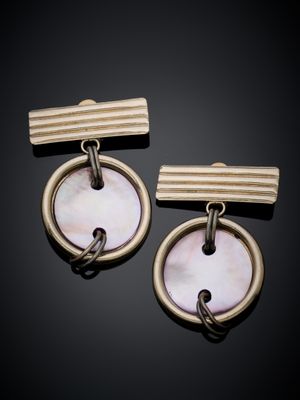 une paire de boucles d'oreilles en or et en nacre sur fond noir