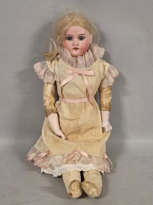 an old fashioned doll sitting on a white surface with a white background