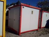 three portable toilets sitting in the dirt next to each other
