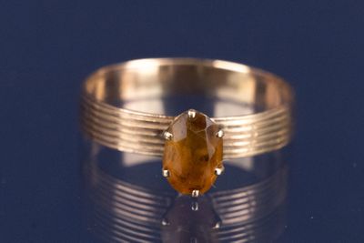 une bague ornée d'une pierre jaune sur un fond bleu
