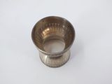 a small silver cup on a white surface with a white background
