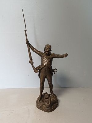 bronze statue of a man holding a rifle and a rifle