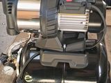 a black compressor on a wooden table with other tools