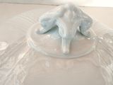 a white plate with a lid that has an elephant on it