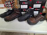 Plusieurs paires de chaussures sont alignées sur une table devant des cartons.