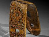 two pieces of wood with carvings on them on a white surface