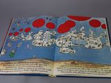 an open book with a picture of a city on it