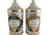 two white and gold canisters with a picture of a woman and a man