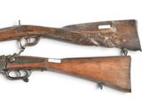 two old guns are on display on a white surface