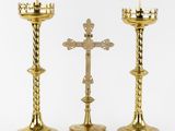 two gold candlesticks with a cross on top of them