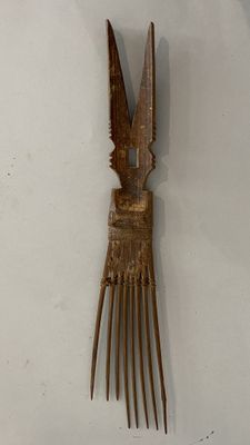 a wooden comb with a bird on it on a white surface