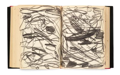 un livre ouvert, sur lequel figure un dessin en noir et blanc, posé sur une surface blanche